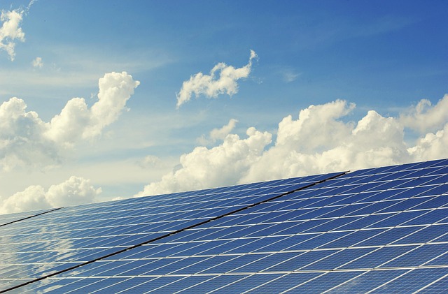 Des panneaux solaires sont visibles sous un ciel bleu ponctué de nuages.